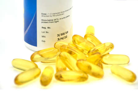 Soft gelatin capsule with manufacturing date and expiry date on some pharmaceutical packaging.の写真素材