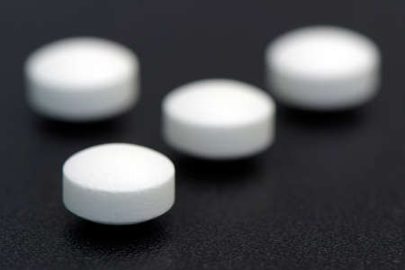 White plain compress tablet on black background in new drug discovery and new treatment concept.の写真素材