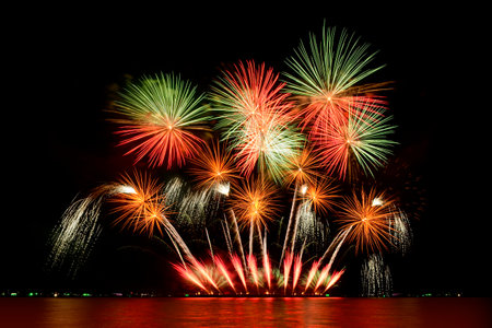 Firework celebration from the sea shore. Colorful fireworks celebration and the night sky background.の写真素材