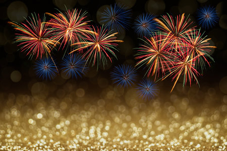 Colourful fireworks celebration and gold bokeh with dark background and copy space. Abstract background holiday.の写真素材