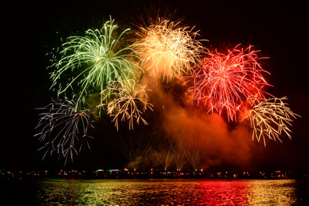 Colorful fireworks celebration and the night sky background with reflection on the water..の写真素材