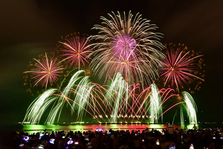 Joyful moment of people capturing fireworks show with camera and smart phone.の写真素材