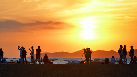 People enjoyed capturing and take photograph the sunset at the beach.の写真素材
