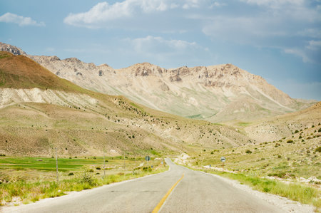 Mountains with countryside road, foliage, grass and cloudy sky in mazandaran province, Iranの写真素材
