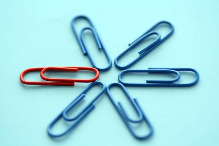 One red paper clips among blue othersの写真素材