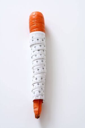 Carrot wrapped in measuring tapeの写真素材