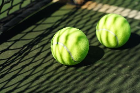 Two tennis balls in a courtの写真素材