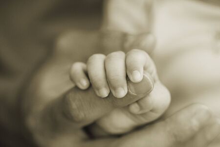 A  holding the hand of his father (shallow DOF)の写真素材