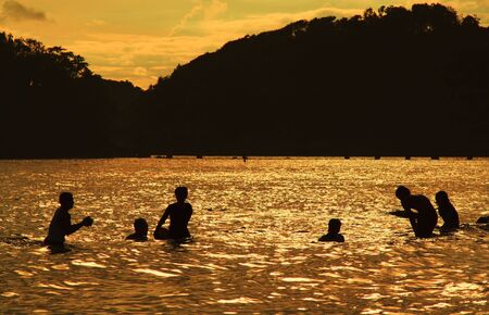 A family enjoying the sunset at the beachの写真素材