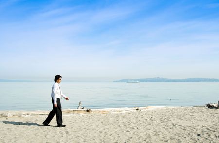 A businessman walking along the beach aloneの写真素材