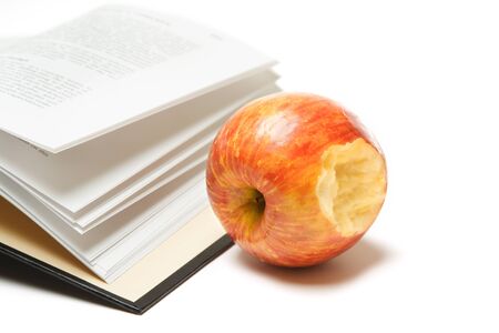 An isolated shot of an open book and an appleの写真素材