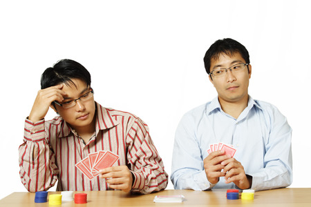 An isolated shot of two men playing poker with one of them cheatsのeditorial素材