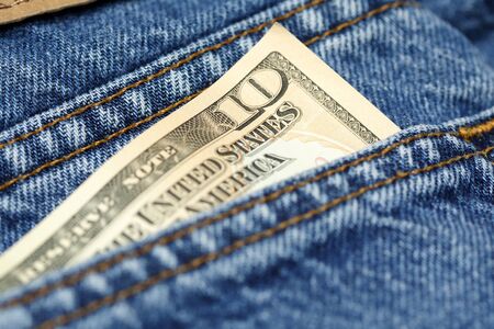 A shot of a ten dollar bill on the back of a blue jeans pocket