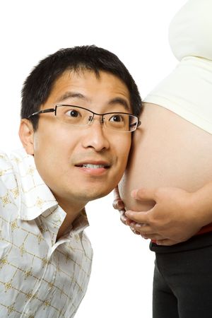 An isolated shot of a father listening to his unborn child