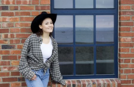 A beautiful young girl posing against a red brick wall の写真素材