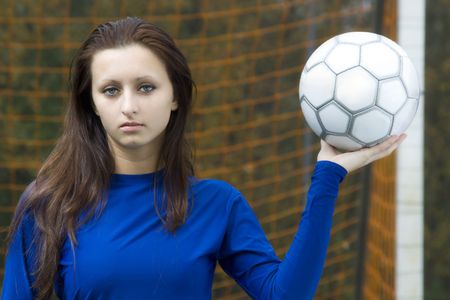 A portrait of a beautiful young woman holding a soccer ballの写真素材