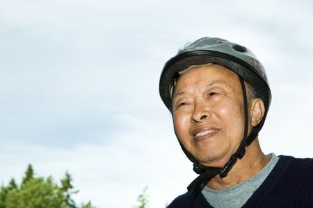 A shot of an elderly asian man wearing a bike helmetの写真素材