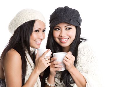 Two beautiful smiling asian women drinking coffeeの写真素材