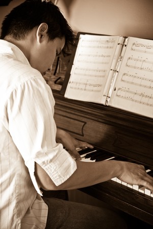 A shot of an asian man playing pianoの写真素材