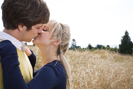 A young caucasian couple in love kissing outdoorの写真素材