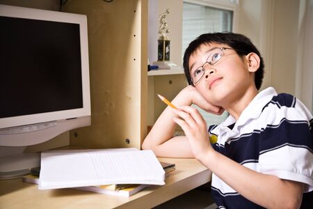 A shot of an asian kid studying at homeの写真素材