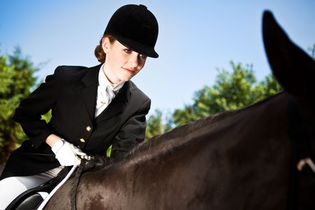 A caucasian teenage girl riding a horse outdoorの写真素材