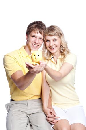A young couple holding a piggy bank, can be used for finance or saving conceptの写真素材