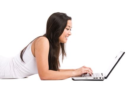 An isolated shot of a happy beautiful asian woman working on her laptopの写真素材