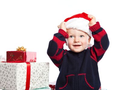 A caucasian boy wearing a santa hat with a lot of christmas giftの写真素材