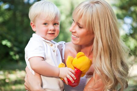 A portrait of a happy caucasian mother with her son outdoorの写真素材