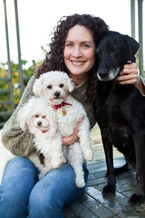 A portrait of a happy mature woman with her dogs outdoorの写真素材