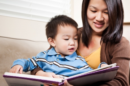 A portrait of a mother and a son reading a bookの写真素材