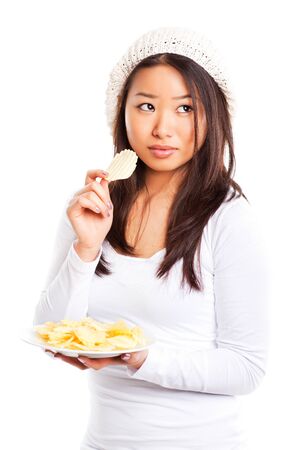 An isolated shot of an asian girl eating potato chipsの写真素材
