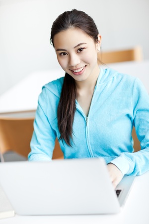 A shot of an Asian college student working on her laptop on campusの写真素材