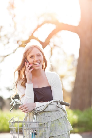 A portrait of a beautiful young Caucasian woman talking on the phone outdoorの写真素材