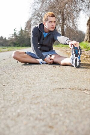 A shot of a mixed race man stretching outdoorの写真素材