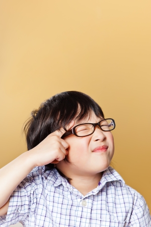 A portrait of a cute asian boy making a funny faceの写真素材