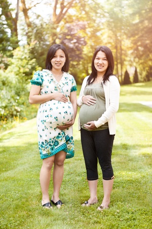 A shot of two beautiful pregnant Asian womenの写真素材