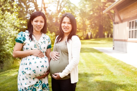 A shot of two beautiful pregnant Asian womenの写真素材