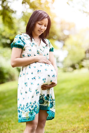 A shot of a beautiful pregnant Asian woman outdoorの写真素材