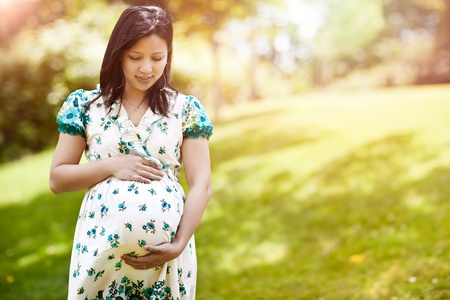 A shot of a beautiful pregnant Asian woman outdoorの写真素材
