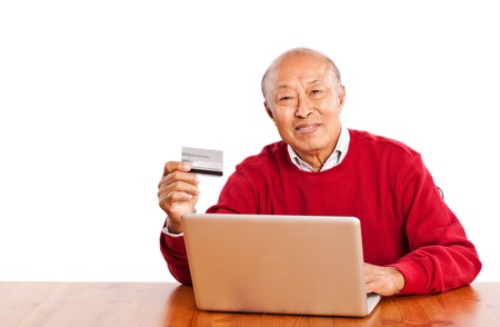 A shot of senior Asian man shopping online celebrating Christmasの写真素材