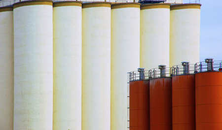 Large silo batteries of white concrete and red steel silo