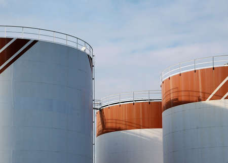 Red and white tanks with rails and a blue skyの写真素材