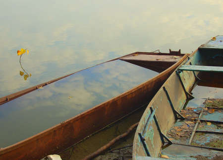 An empty boat and a boat full of water の写真素材