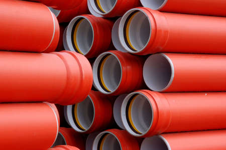 Stack of red pipes at an industrial siteの写真素材