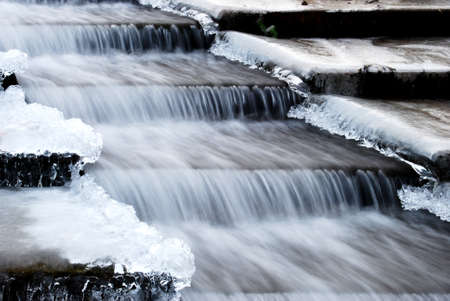 Waterfall on frozen steps in winterの写真素材