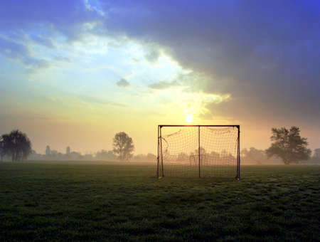 Small soccer goal on a meadow at early morningの写真素材
