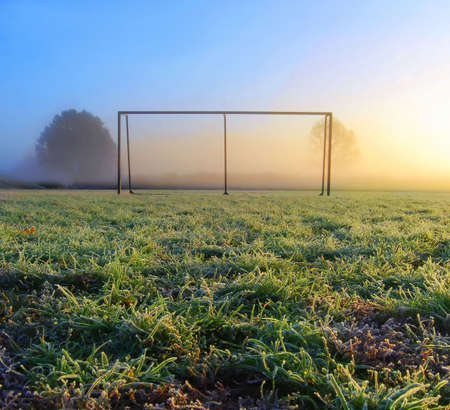 Soccer goal on a frozen sport field on a foggy morningの写真素材