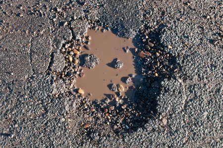 Water filled pothole on a asphalt streetの写真素材